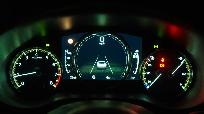 schwarz-weiss-kombiinstrument Beleuchtetes Armaturenbrett eines Autos bei Nacht. In der Mitte zeigt ein digitales Display 0 mph und eine Spurhaltegrafik. Links ist ein Drehzahlmesser und rechts Analoganzeigen für Kraftstoff und Motortemperatur zu sehen.
