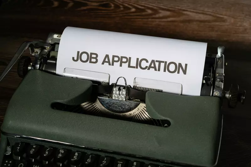 Schreibmaschine mit einem Blatt mit der Überschrift "Job application"